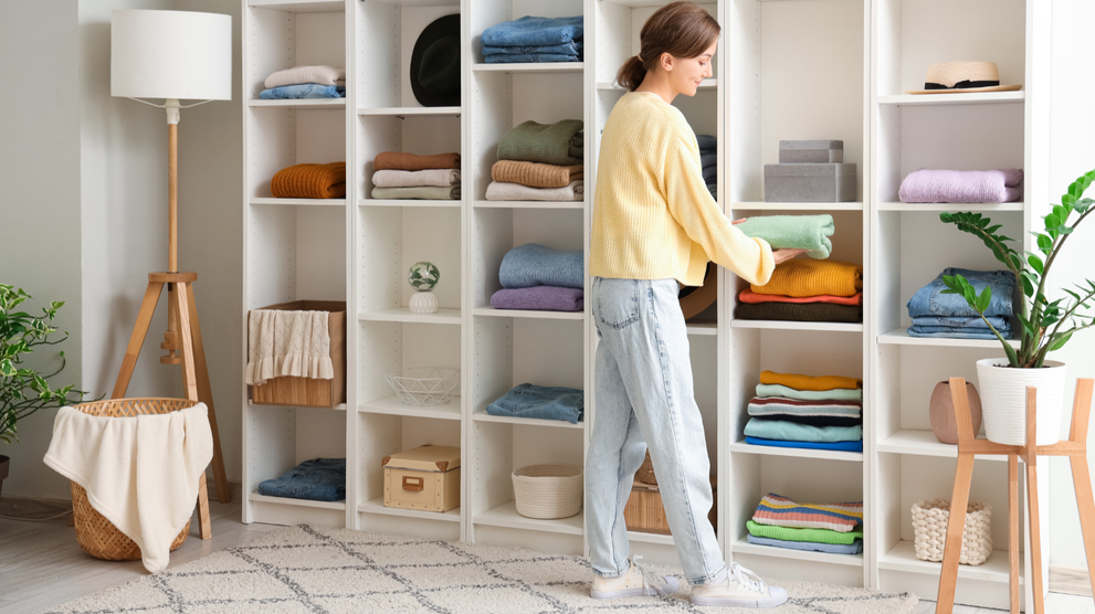 Woman organizing clothes on closet shelving