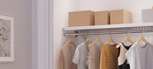 Closet with clothes on hangers and storage boxes on a shelf.