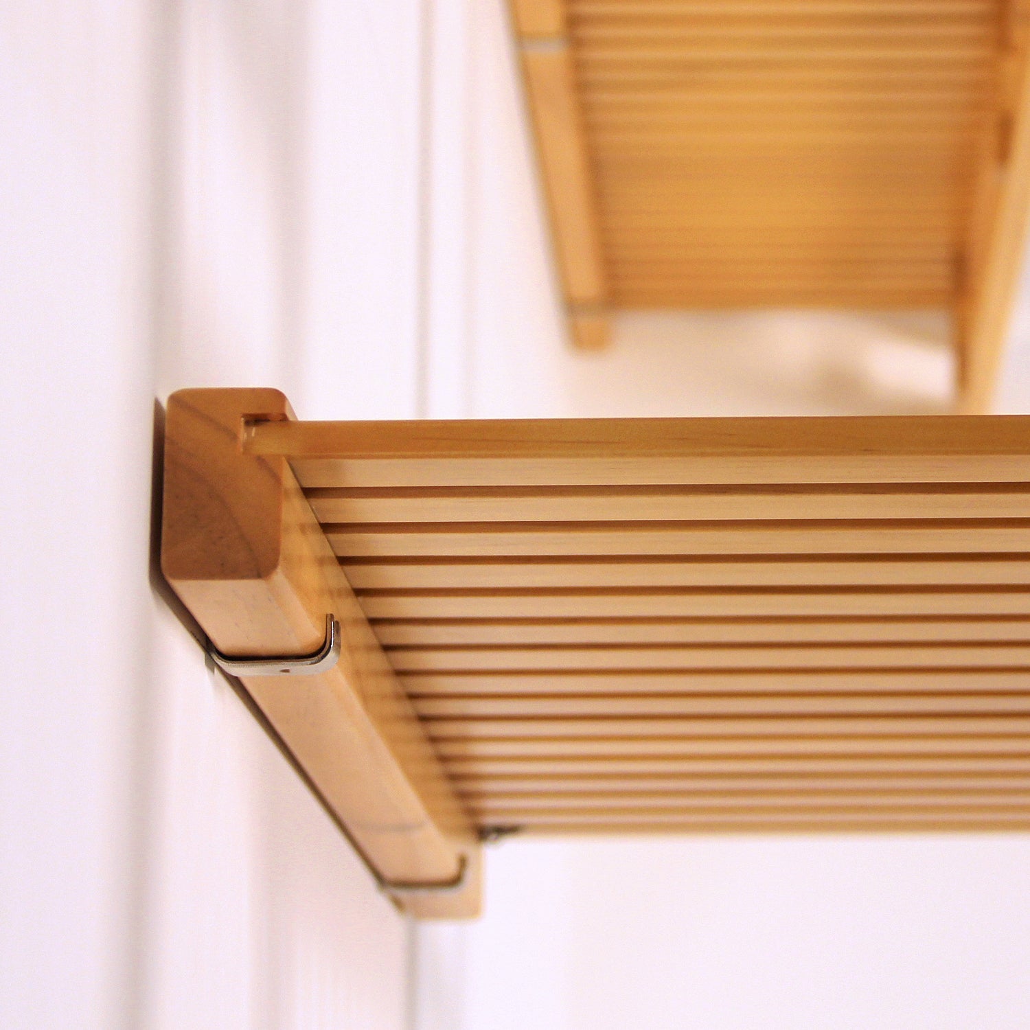 Wooden shelf with mounting hardware bracket on a white wall