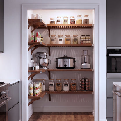 A small L shaped walk-in pantry with four levels of chestnut solid wood shelving filled with grocery items.