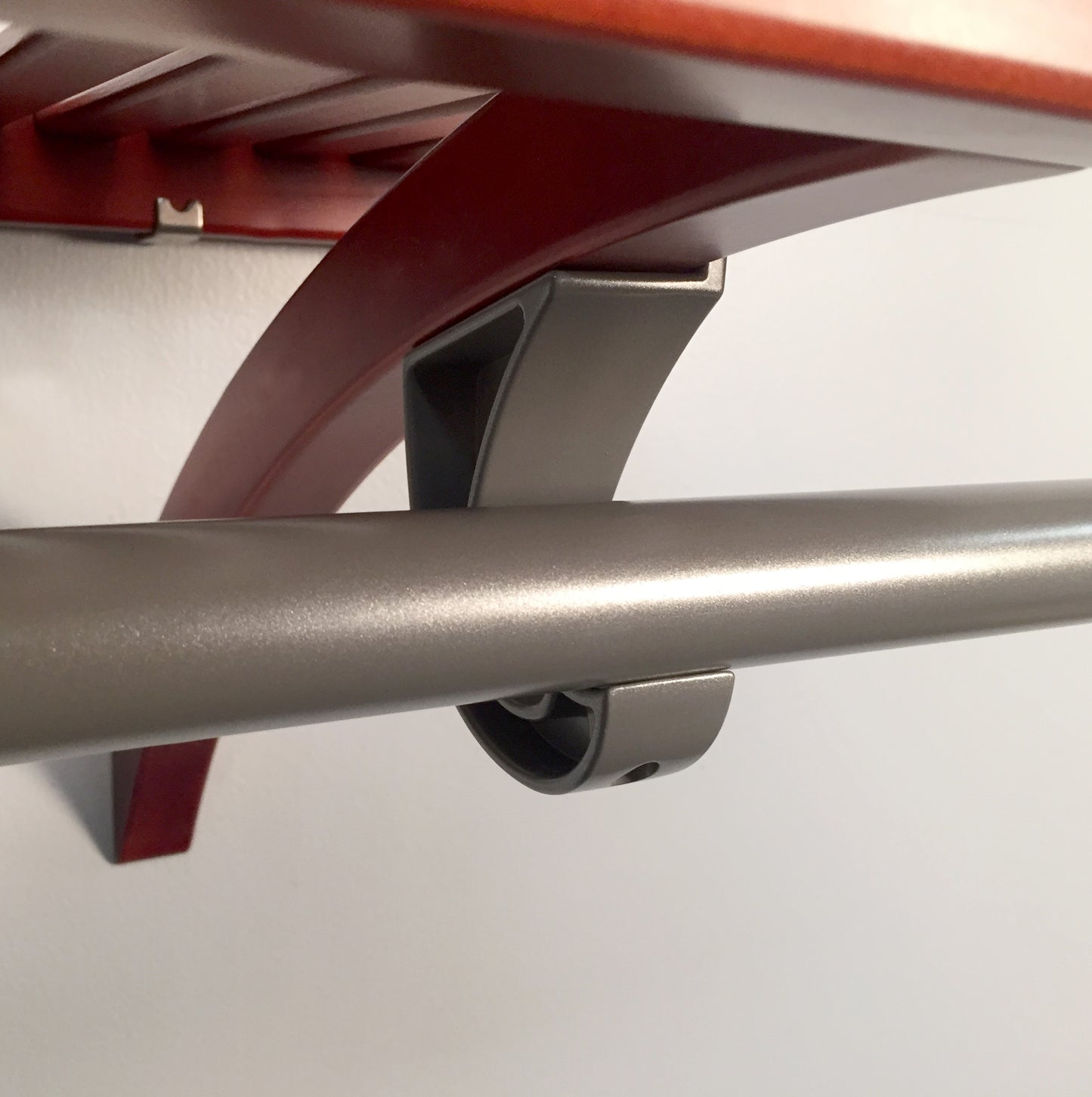 close up of garment bar with j -hook attached to wooden shelf