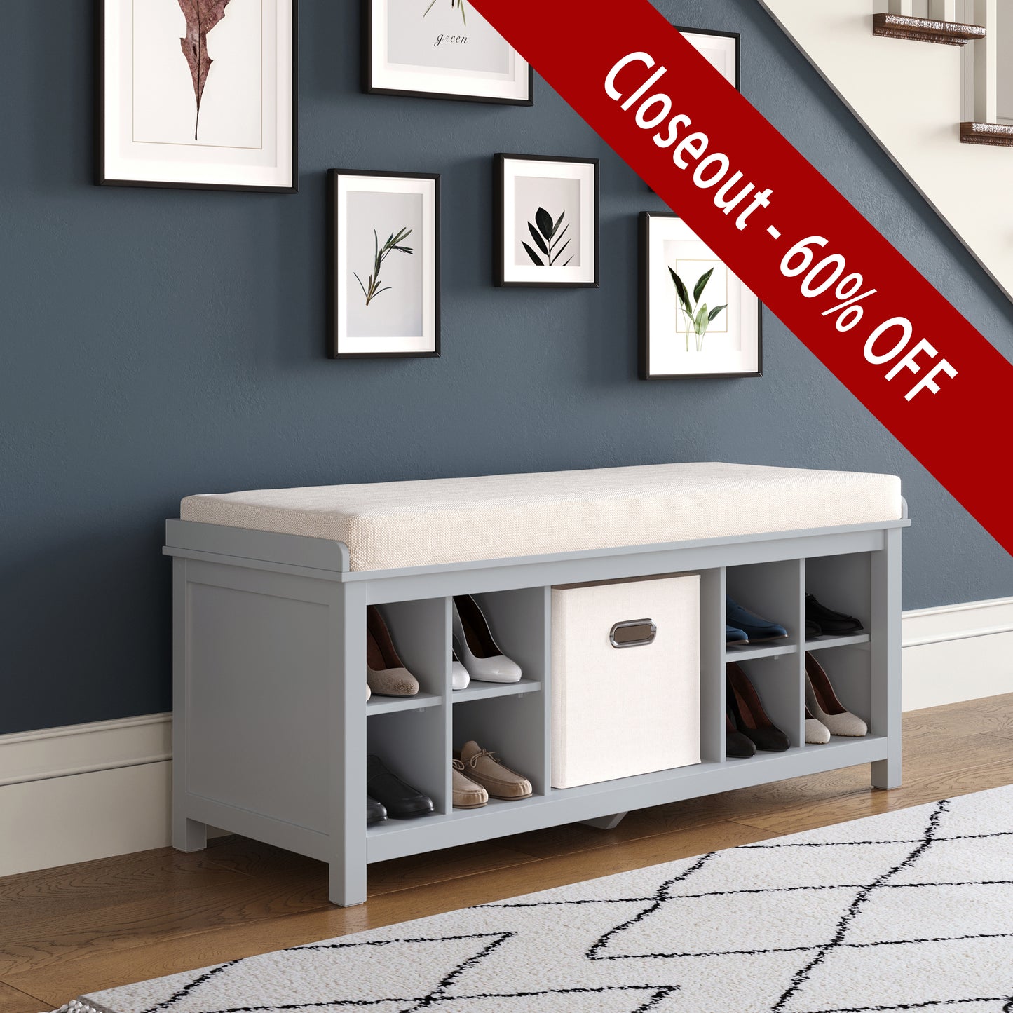 Gray storage bench with cushioned top in a room with framed pictures on the wall.
