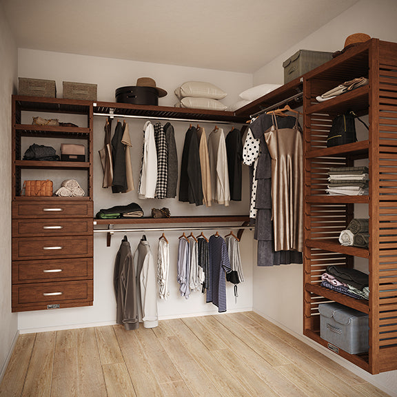 Chestnut L Shaped walk in closet organizer with 5 drawers,  clothes and hanging in a room.