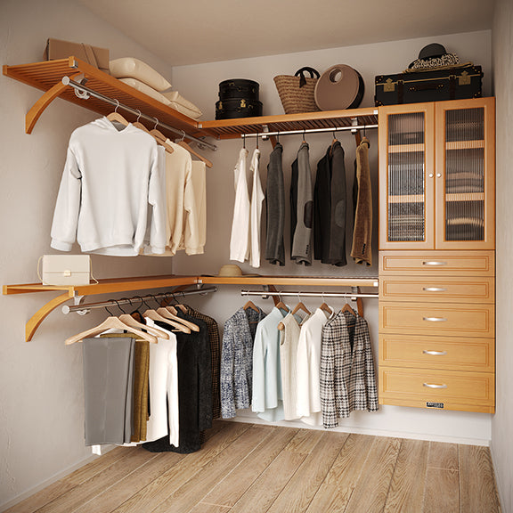 Honey Maple L Shaped walk in closet organizer with 5 drawers and doors,  clothes and hanging in a primary bedroom closet.