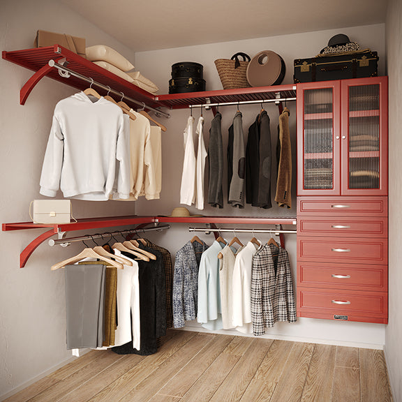 Red Mahogany L Shaped walk in closet organizer with 5 drawers and doors,  clothes and hanging in a primary bedroom closet.