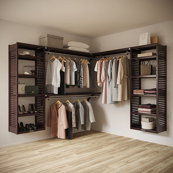 Espresso L Shaped walk in closet organizer with clothes and shoes in a room.