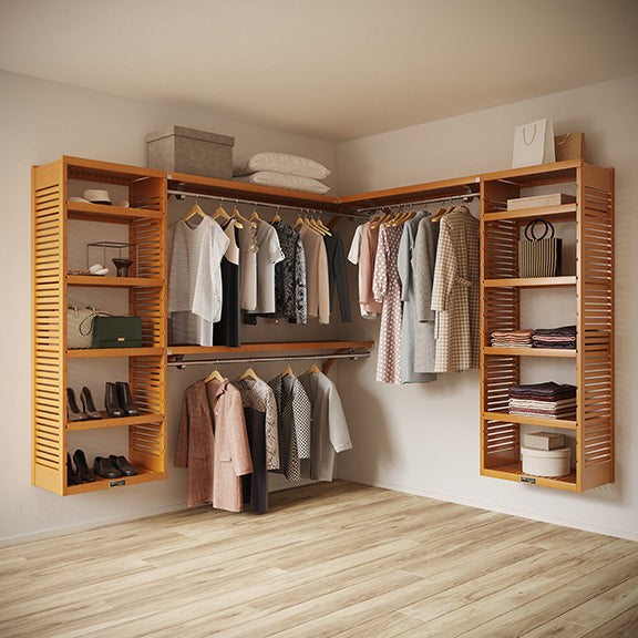 Honey Maple L Shaped walk in closet organizer with clothes and shoes in a room.
