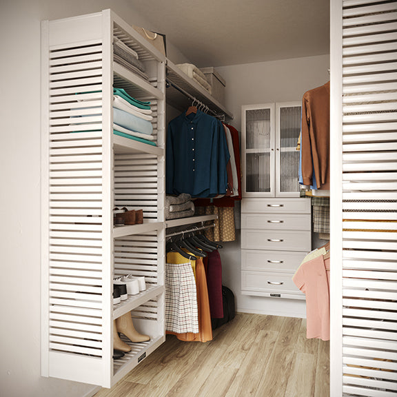 White U shaped  closet organizer with doors, drawers, clothes and shelves in a room.