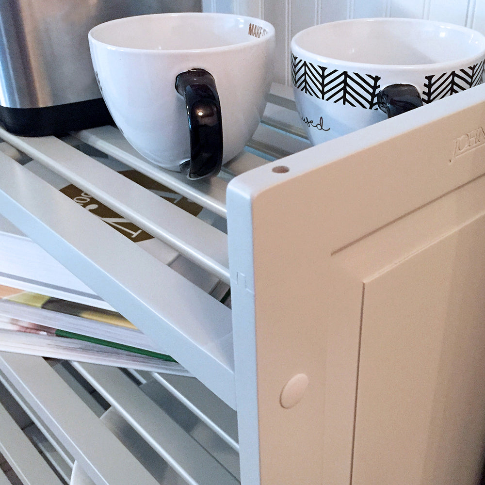 close up details of the slatted shelves on a  grey 3 tiered shelving rack