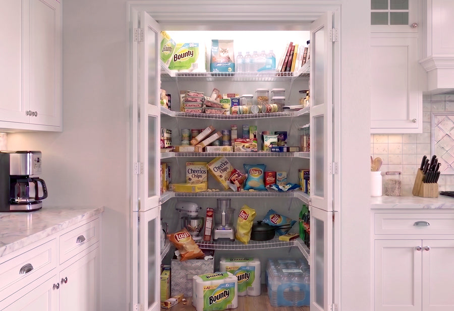 A before image of a fully stocked pantry with white wire shelves that are bowing and sagging with the weight of tipped groceries.