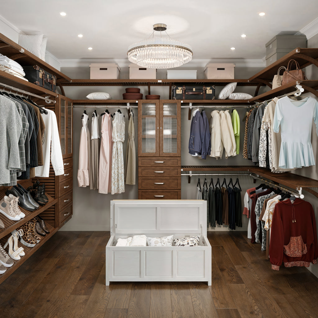 After remodel Modern walk-in closet with wooden shelves, clothes, and a storage bench.