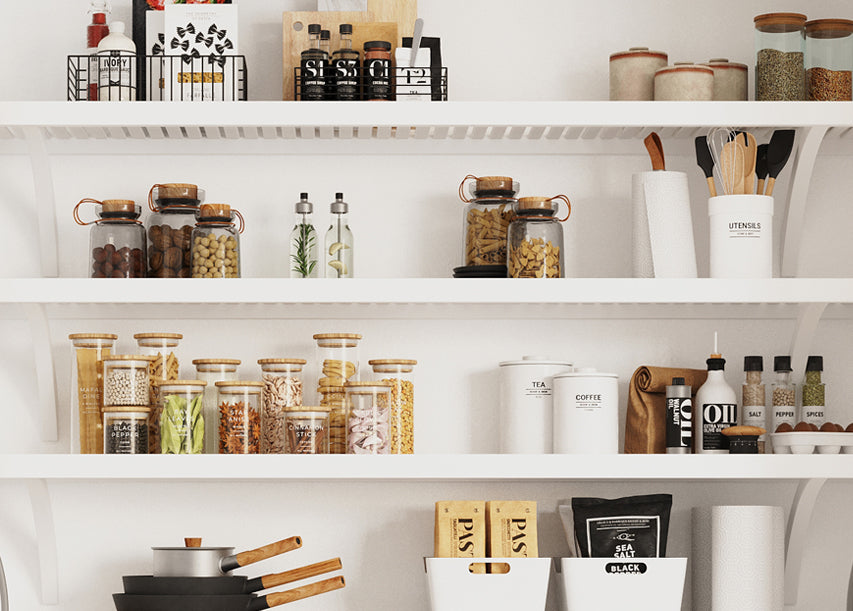 A bright, clean kitchen pantry with white shelves stocked with glass jars, canisters, utensils, and food containers in a minimalist, modern style.