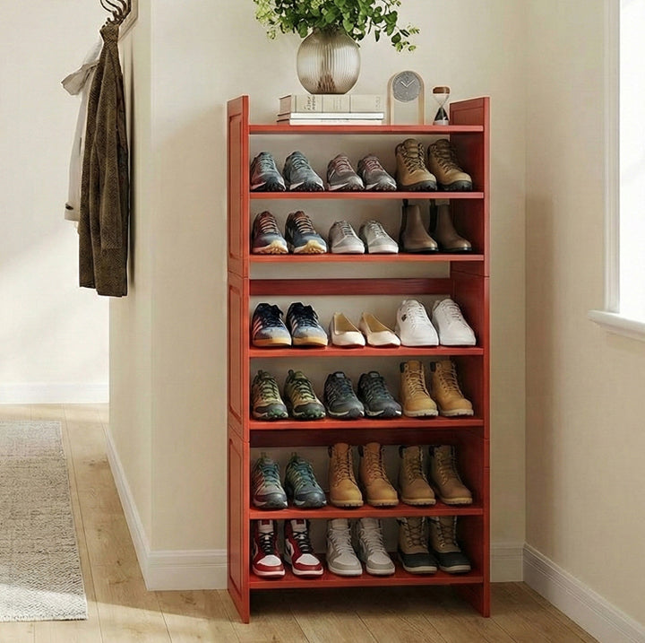 Red shoe rack with various shoes on a wooden floor in a home setting.