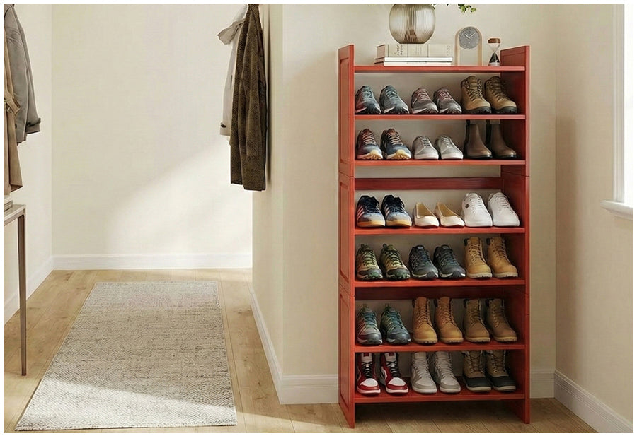 Red shoe rack with various shoes on a wooden floor in a room.
